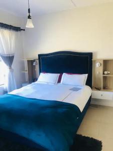 a bedroom with a large bed with a blue headboard at Luxurious Lifestyle in Cape Town