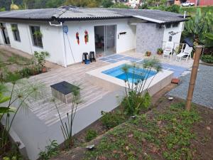a house with a deck and a swimming pool at Finca La Primavera in Manizales