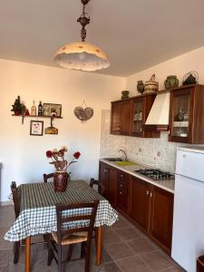una cucina con tavolo e piano cottura forno superiore di La casa nella Pinetina ad Alfedena
