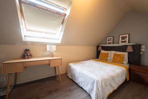 een slaapkamer met een bed, een raam en een bureau bij Bellevue sur Sèvres in Sèvres