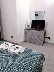 a bedroom with a bed and a dresser with a tv at Case vacanze Rosa in Siniscola