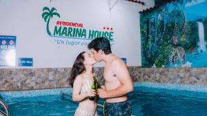 a couple kissing in front of a swimming pool at Residencial Marina House in Tarapoto