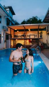 Un uomo e una donna in piedi in una piscina di Residencial Marina House a Tarapoto