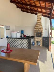 a kitchen with a wooden table and a brick oven at Meu Chale Flecheiras in Flecheiras