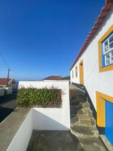 een witte muur met een heg aan de zijkant van een gebouw bij Casa da Lapa in Angra do Heroísmo