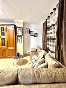 una sala de estar con un sofá grande en una habitación en Chrigrey Holiday Apartments & Durres Beach, en Durrës