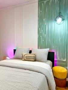 ein Schlafzimmer mit einem großen Bett und einem gelben Stuhl in der Unterkunft Charmant Appartement Duplex au calme in Évreux