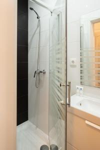 una ducha con una puerta de cristal junto a un lavabo en Spacious Modern Flat w/ Balcony, en Oporto