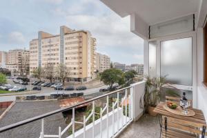 uma varanda com uma mesa e vista para a cidade em Spacious Modern Flat w/ Balcony no Porto