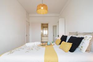 una gran cama blanca con almohadas y una mesa. en Spacious Modern Flat w/ Balcony, en Oporto