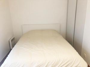 ein kleines weißes Bett in einem kleinen Schlafzimmer in der Unterkunft La suite Prestige de Saint Cyr in Saint-Cyr-lʼÉcole