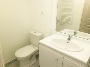 ein weißes Bad mit einem WC und einem Waschbecken in der Unterkunft La suite Prestige de Saint Cyr in Saint-Cyr-lʼÉcole