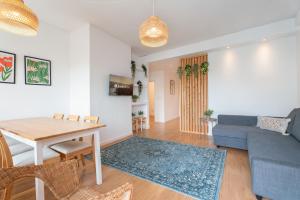 uma sala de estar com uma mesa e um sofá azul em Spacious Modern Flat w/ Balcony no Porto