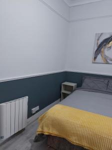 a bedroom with a bed with a yellow blanket on it at The corner house Longford town in Longford