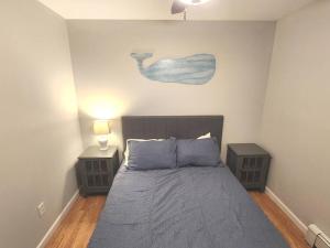 um quarto com uma cama com duas mesas de cabeceira e um quadro na parede em Bobby's Beach Bungalow em Milford