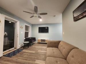 a living room with a couch and a ceiling fan at Bobby's Beach Bungalow in Milford