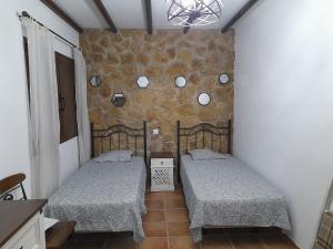 two beds in a room with a stone wall at Casa victoria in Soo