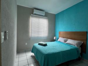 a bedroom with a bed with a blue wall at Maaya in Puerto Morelos