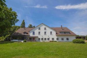 une grande maison blanche avec une grande cour dans l'établissement Landsitz Lippoldsberg, à Gewissenruh