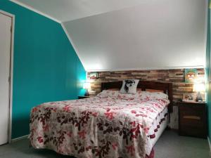 a bedroom with a bed with a red and white blanket at Alojamiento Casa completa en Puerto Montt in Puerto Montt