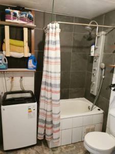 a bathroom with a toilet and a shower curtain at Alojamiento Casa completa en Puerto Montt in Puerto Montt