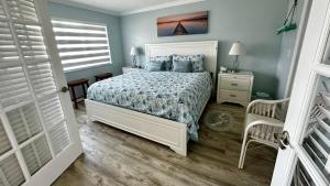 Schlafzimmer mit einem Bett mit blauen Wänden und einem Fenster in der Unterkunft Ocean Village in Fort Pierce