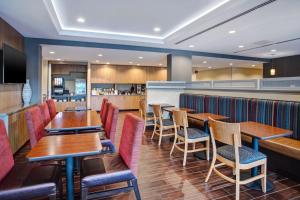 ベルビルにあるTownePlace Suites by Marriott Detroit Bellevilleの木製のテーブルと椅子のあるレストラン、バー