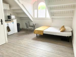 a bedroom with a bed and a table and a kitchen at Studio Cosi Sxm in Marigot