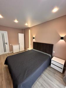 a bedroom with a large black bed in a room at Park House in Palyanytsya