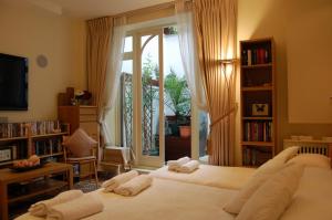 two beds in a living room with a window at Georgiana's Guesthouse in London