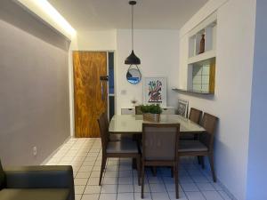 uma sala de jantar com mesa e cadeiras em Apartamento 2 quartos 1km da Praia no Recife