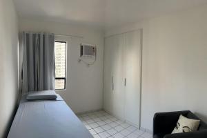 um quarto com uma cama e uma televisão na parede em Apartamento 2 quartos 1km da Praia no Recife