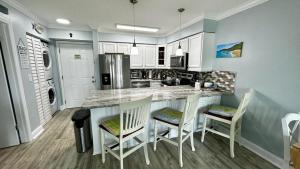 eine Küche mit einer Insel mit Stühlen und einer Arbeitsplatte in der Unterkunft Ocean Village in Fort Pierce