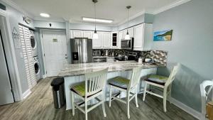 a kitchen with a island with chairs and a counter top at Ocean Village in Fort Pierce