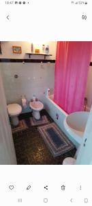 La salle de bains est pourvue d'un rideau de douche rose et de toilettes. dans l'établissement Al casale, à Capriglia