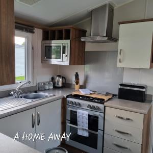a kitchen with a stove and a sink at A HOME AWAY AT Tattershall country park in Tattershall