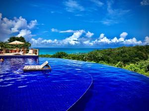 a swimming pool with blue water in a resort at Villas do Pratagy VIP in Maceió