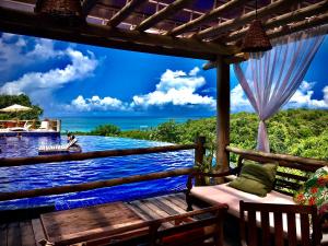 une terrasse avec vue sur l'océan et un bateau dans l'établissement Villas do Pratagy VIP, à Maceió