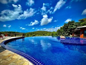 a swimming pool with a blue sky in the background at Villas do Pratagy VIP in Maceió