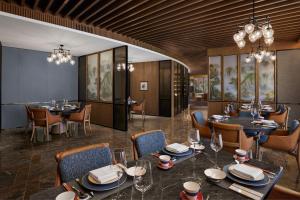 a dining room with tables and chairs and chandeliers at Sheraton Chengdu Lido Hotel in Chengdu