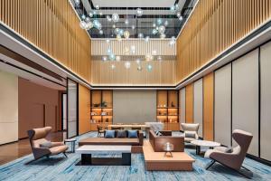 a lobby with a couch and tables and chairs at Fairfield by Marriott Beijing Daxing Airport in Beijing