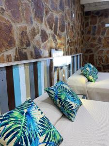 a room with two beds with blue and green pillows at Posada 21 Oranges in Puerto Iguazú