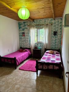 1 dormitorio con 2 camas y lámpara de araña en Lothbrok House en Villa Rumipal