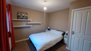 um pequeno quarto com uma cama e prateleiras em Spacious 3 bedroom home em Kilcock