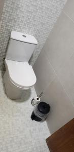 a white toilet in a bathroom with a hose at Casa verde in Campo Grande +6 photos