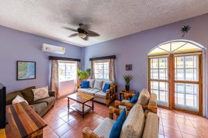 a living room with couches and a ceiling fan at Casa del Rai in San Pedro