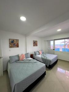 sala de estar con 2 camas y sofá en Hotel Molino de Viento, en San Andrés