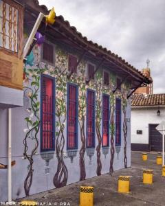 un edificio con árboles pintados a un lado. en HOSTAL CHONTADURO Casa colonial en pleno centro histórico de Cali- Se alquila la casa entera para 12 o 13 personas o por habitaciones en Cali