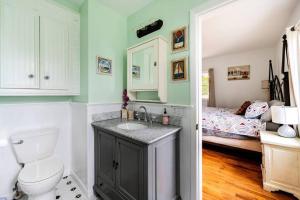 1 cama y baño con lavabo y aseo. en Greenport village cottage w/ 4 bedrooms en Greenport