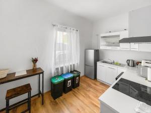 Il comprend une cuisine avec des placards blancs et du parquet. dans l'établissement CityChalet Monteur Apartments, à Sarrebruck